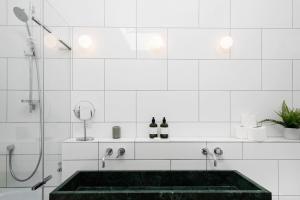 a white bathroom with a tub and a shower at Stylish Modern 2 Bedroom Apartment near Shoreditch in London