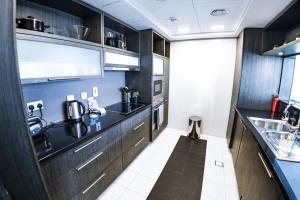 a kitchen with dark wood cabinets and a sink at Luxurious 1 Bedroom Downtown in Dubai