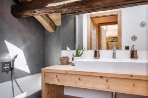 a bathroom with a white sink and a mirror at Nouveau et spacieux, Place de l'Eglise et terrasse privative in La Clusaz