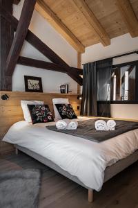 ein Schlafzimmer mit einem großen Bett mit drei Handtüchern darauf in der Unterkunft Nouveau et spacieux, Place de l'Eglise et terrasse privative in La Clusaz