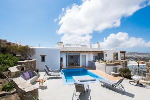 a villa with a swimming pool and a house at Mykonos Village in Ano Mera