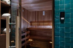 una sauna con paredes de madera y una pared de azulejos azules en Victoria Palace Hotel, en París