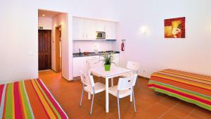 a kitchen with a table and chairs in a room at Parque de Campismo da Ilha do Pessegueiro in Porto Covo