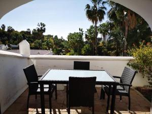 a table and chairs on a balcony with palm trees at El Capistrano in Nerja