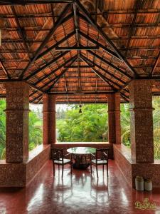 a room with a table and chairs and a large window at POOTHALI HOMESTAY in Nīleshwar