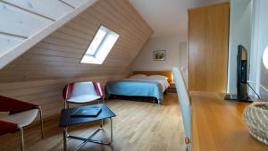 a attic bedroom with a bed and two chairs at Hôtel du Cheval Blanc - City center in Bulle