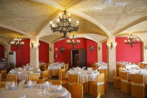 jadalnia z białymi stołami i krzesłami oraz żyrandolem w obiekcie Hostal El 402 w mieście Iznalloz