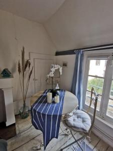 une table à manger avec un tissu de table rayé bleu et blanc dans l'établissement Les Cieux de la Cathédrale - Calme - Jardin - Wifi, à Troyes