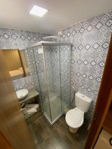 a small bathroom with a toilet and a shower at Swell Praia Hotel in Natal