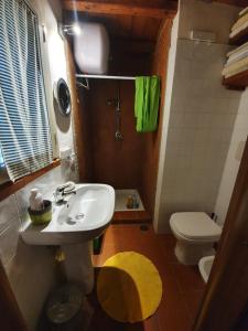 ein Badezimmer mit einem weißen Waschbecken und einem WC in der Unterkunft Il Piccolo Borgo in Montalto di Castro