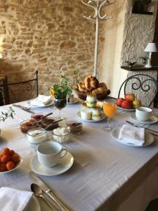 a table with breakfast foods and drinks on it at La Mandarine in Piolenc