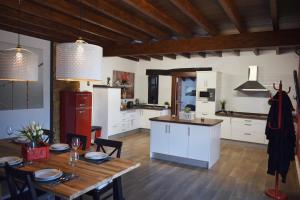 Una cocina con gabinetes blancos y una mesa de madera. en Casa La Masía, en La Orotava