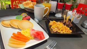 a table with a plate of food and a tray of breakfast foods at Essenzia de Cancun in Cancún