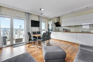 a kitchen and living room with a table and chairs at Wave Apartments - Albatros in Gdańsk