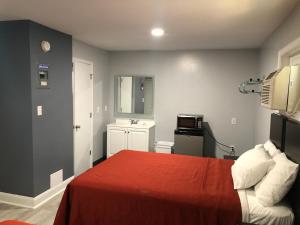 a bedroom with a bed with a red blanket at Bay Inn Hotel in North Camellia Acres