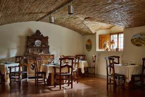 a dining room with tables and chairs and a clock at Villa La Commenda Concordia in Molezzano
