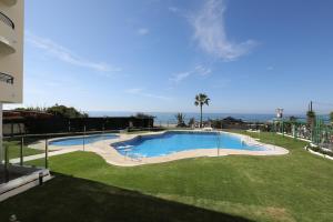 a large swimming pool with the ocean in the background at Banana Beach primera línea de playa in Marbella