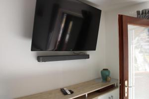 Elle comprend une télévision à écran plat suspendue au mur. dans l'établissement Haus Waldfrieden, à Sautens