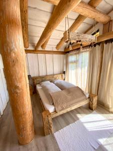 - une chambre avec un lit dans une pièce dotée de plafonds en bois dans l'établissement Gazdovský dvor B&B s Mini Wellness, à Bešeňová