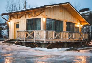 a log cabin with a porch in the snow at Gazdovský dvor B&B s Mini Wellness in Bešeňová