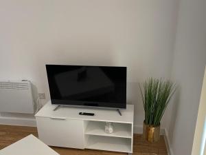 a flat screen tv on a white entertainment center at 1 bedroom lovely apartment in Salford quays free street parking subject to availability in Manchester