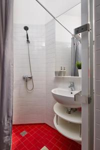 La salle de bains est pourvue d'un lavabo et d'une douche. dans l'établissement Supercosy Apartment at Žižkov, à Prague
