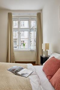 - une chambre avec un lit doté d'une fenêtre et un livre dans l'établissement Supercosy Apartment at Žižkov, à Prague