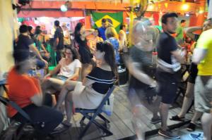 um grupo de pessoas sentadas e de pé numa multidão em Ramon Hostel Bar no Recife