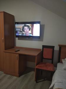 a room with a desk with a television on the wall at Strumykowa in Wyszków