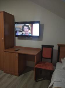 Habitación con escritorio y TV en la pared. en Strumykowa en Wyszków