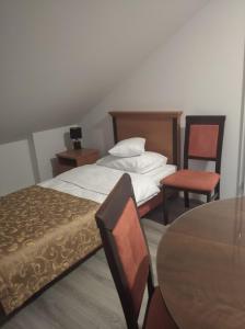 1 dormitorio con 1 cama, mesa y sillas en Strumykowa, en Wyszków