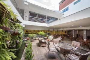 an indoor patio with chairs and tables and plants at Hotel Metropolitano in Coronel Fabriciano
