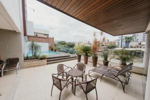 a balcony with tables and chairs and a view of a city at Hotel Metropolitano in Coronel Fabriciano