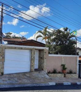 uma casa com portas brancas de garagem numa rua em Meu cantinho em Serra Negra