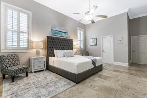ニューオーリンズにあるHosteeva Modern Condo Near Magazine St & Close to FQのベッドルーム1室(ベッド1台、椅子、シーリングファン付) +46枚の写真