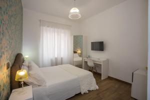 1 dormitorio con cama blanca, escritorio y TV en Comfy Vatican Suite, en Roma