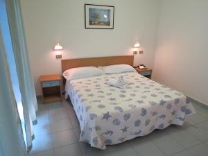 ein Schlafzimmer mit einem Bett und zwei Nachttischen in der Unterkunft Hotel Gemini in Rimini