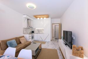 ein Wohnzimmer mit einem Sofa und einem TV in der Unterkunft Лукс Апартамент Радост 2 in Sandanski
