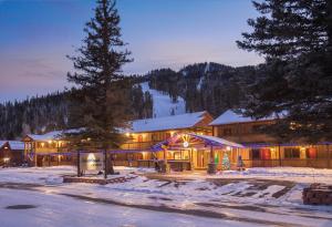 a lodge in the snow with a pine tree at WorldMark Red River in Red River