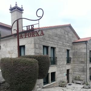 a building with a sign on the side of it at Hotel A Forxa Cafetería Restaurante in Carballeira