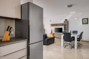 a kitchen and living room with a refrigerator and a table at Villa Ester in Pula
