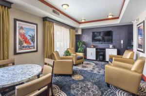 een wachtkamer met een tafel en stoelen en een televisie bij WorldMark San Diego - Balboa Park in San Diego