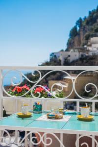 a blue table with cups and saucers on a balcony at Casa Pietro in Positano