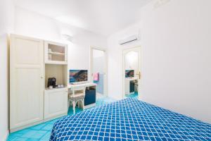 a white room with a bed and a desk at Casa Pietro in Positano
