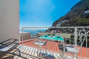 a patio with a table and chairs on a balcony at Casa Pietro in Positano