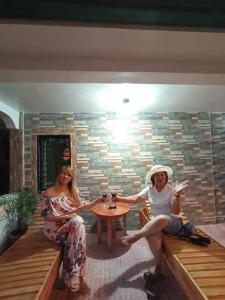 zwei Frauen an einem Tisch in einem Zimmer in der Unterkunft La Frezza Beach House in Bayawan