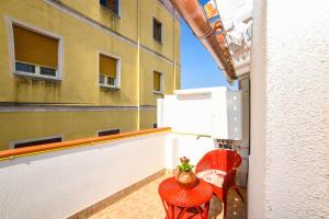 a balcony with a red chair and a vase on it at Casa Marta IUN Q1985 in Nuoro