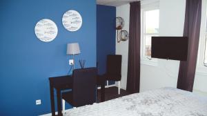 a bedroom with a desk and a blue wall at Hotel Willemstad in Willemstad