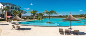 a swimming pool with chairs and umbrellas on a beach at The Blyde 104 in Pretoria