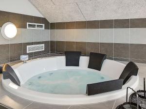 a large bath tub with chairs in a bathroom at 12 person holiday home in Hasselberg in Kappeln